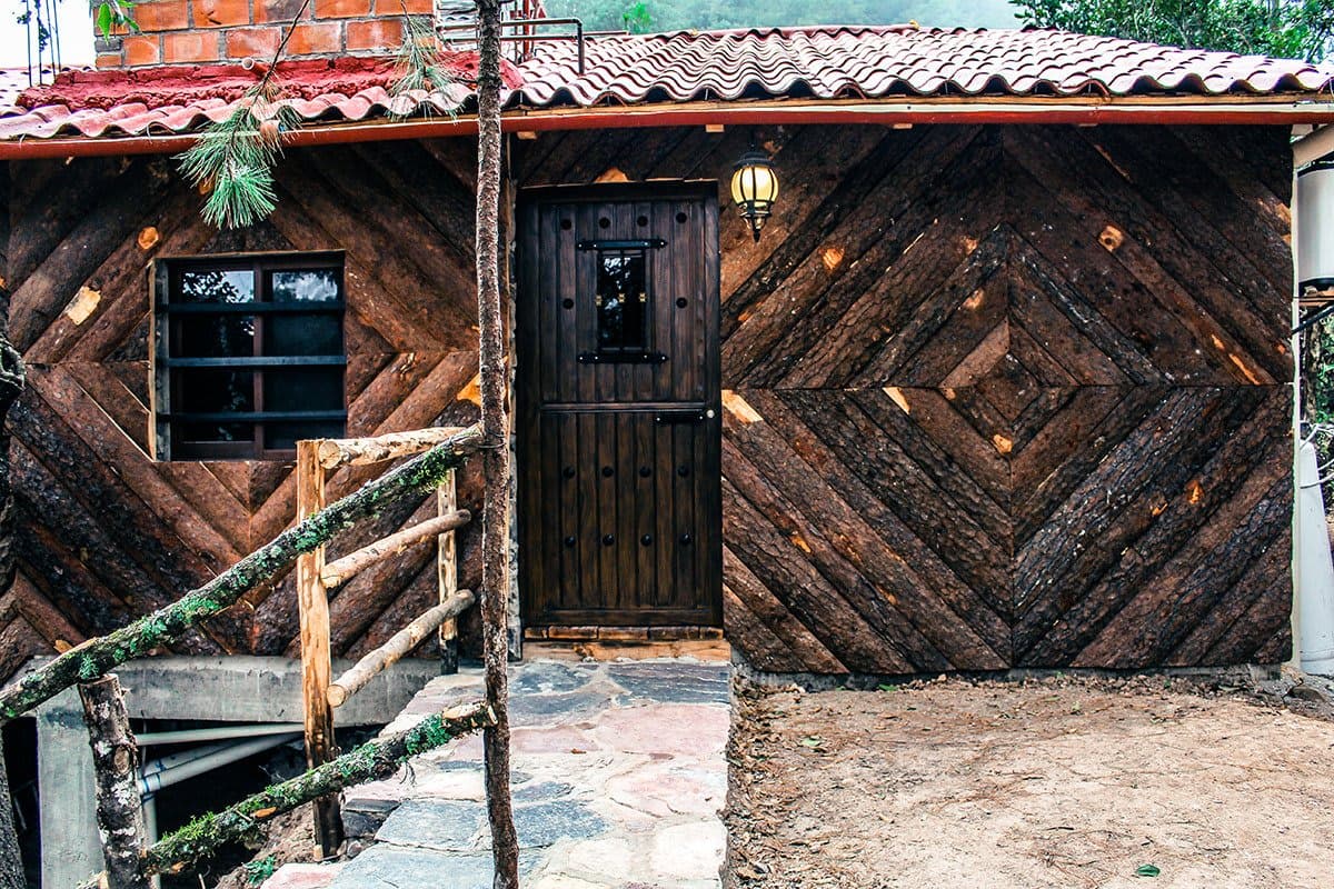 Fachada de la cabaña con puerta de madera